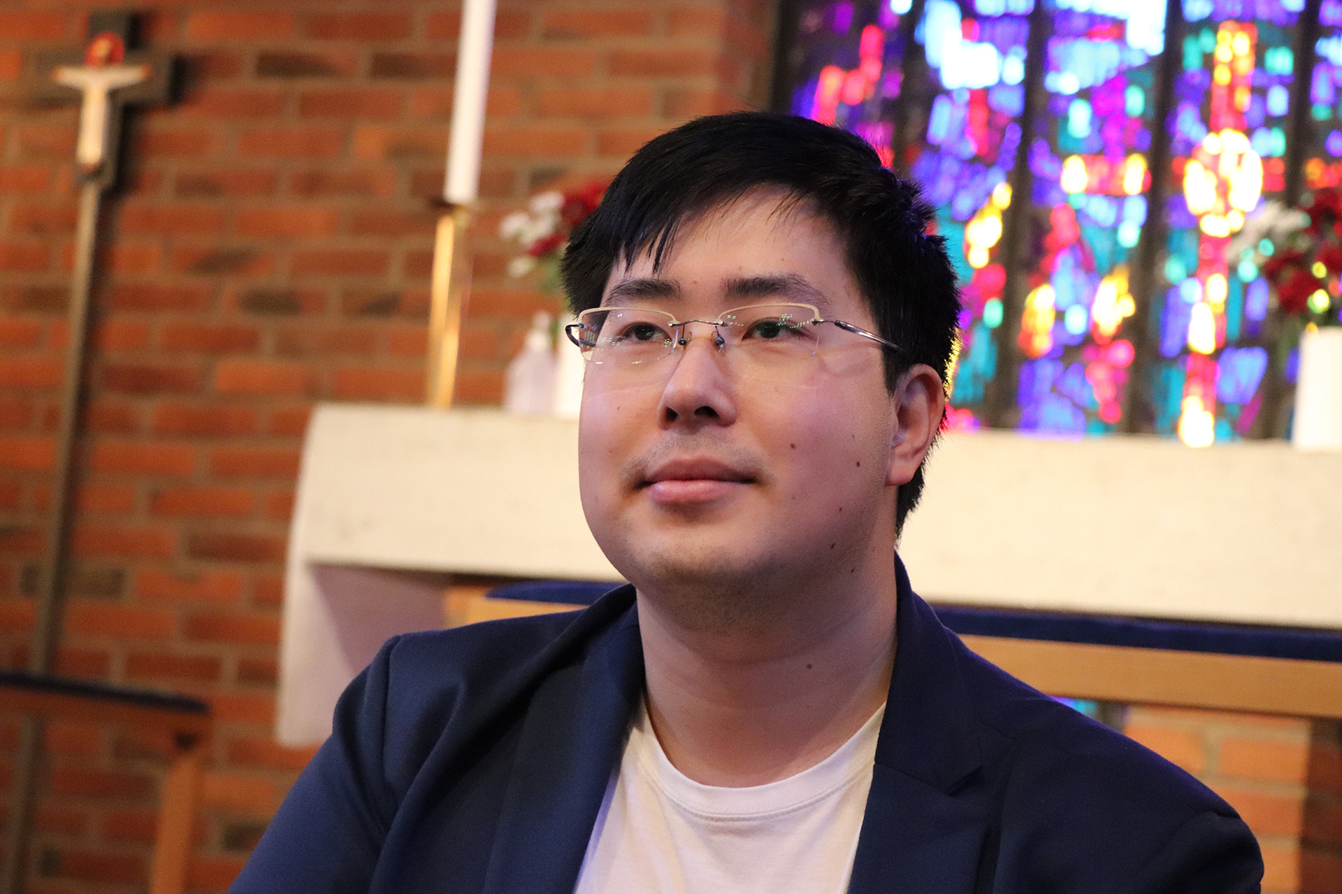 Ett foto på Henric Liu med ett altare i bakgrunden.