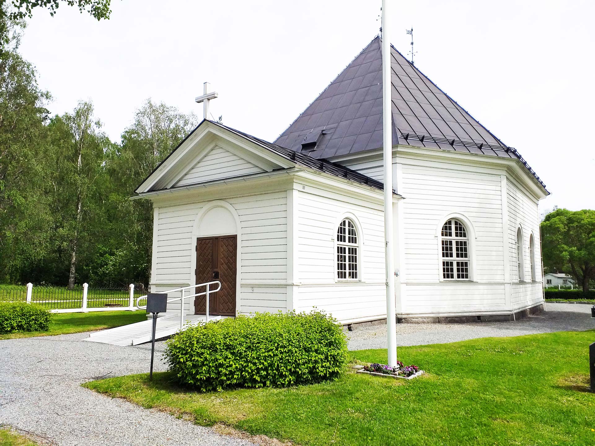 Graninge kyrka omgiven av försommargrönska.