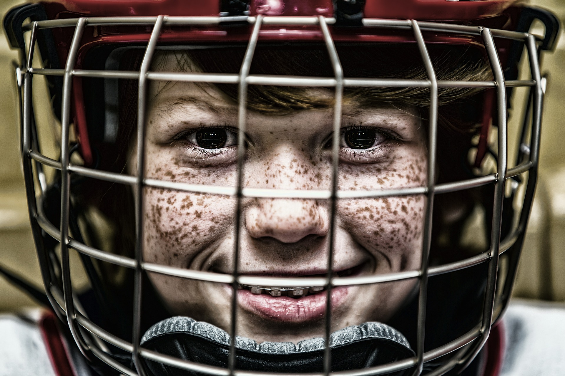 Ett ansikte på ett barn som har en hockeyhjälm på sig.