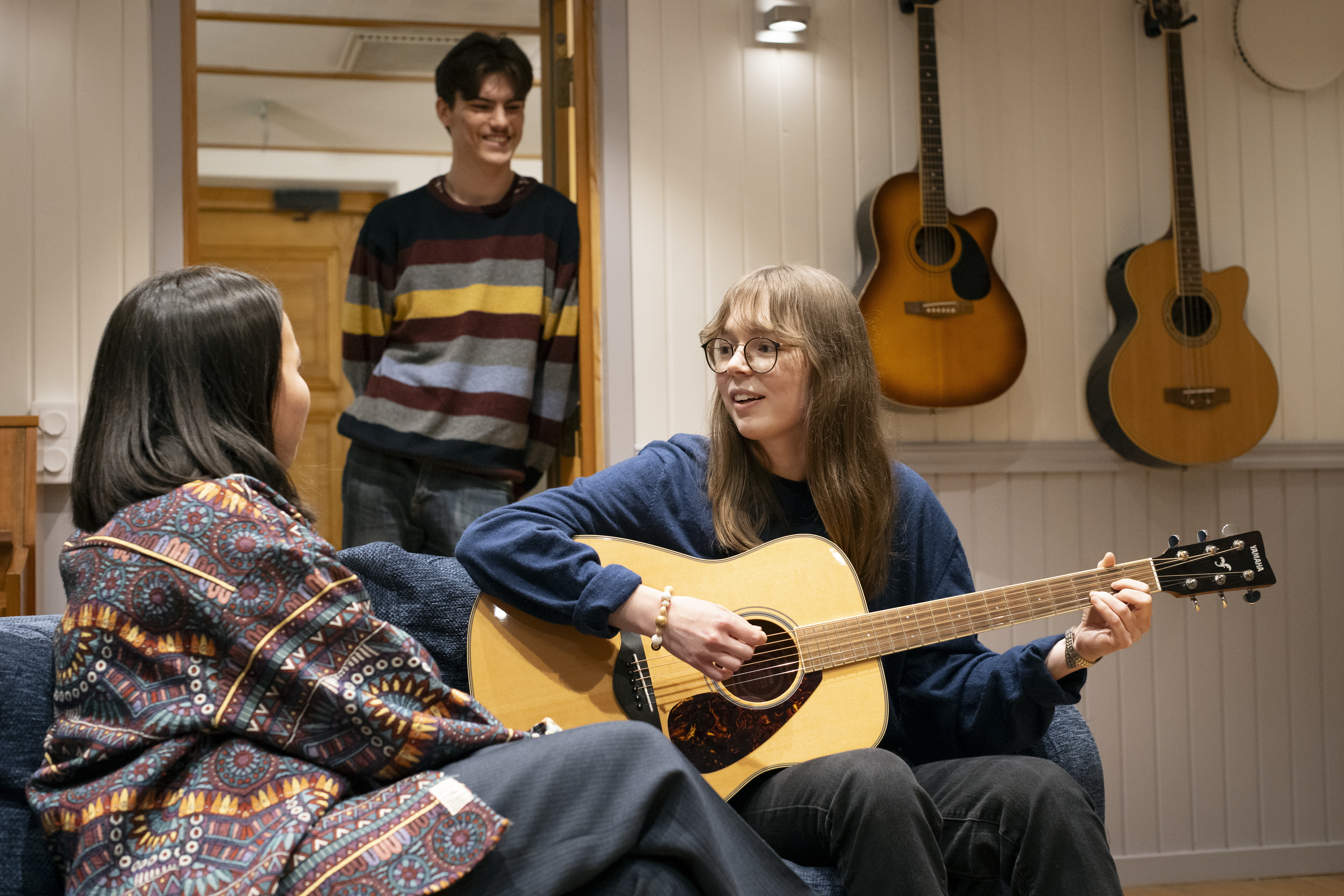 En person med gitarr som samtalar med en annan.