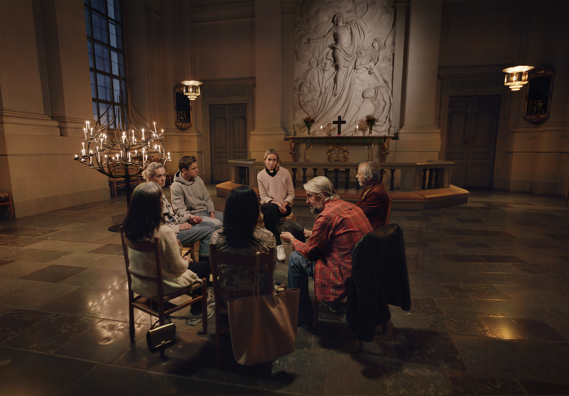 En grupp människor sitter i en ring och samtalar i ett kyrkorum