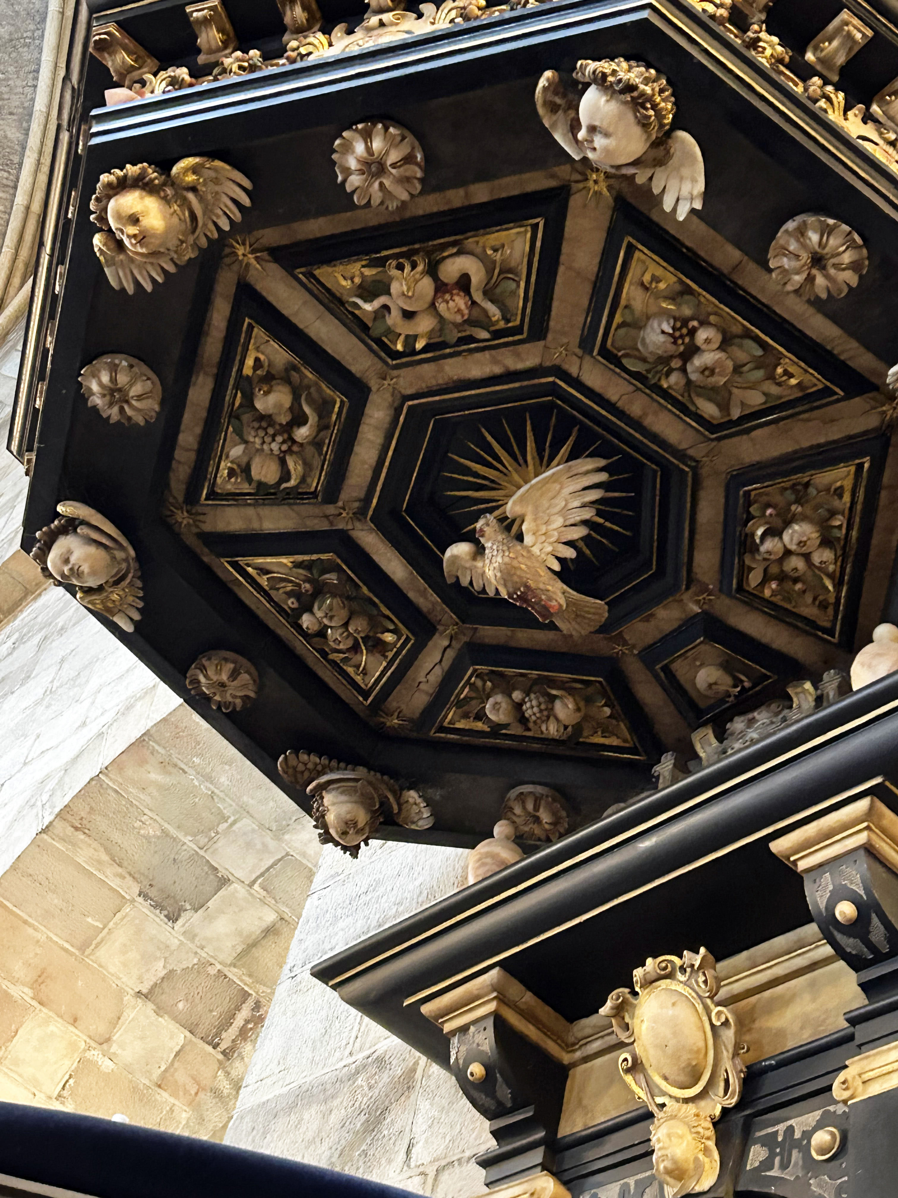 Guldfärgad duva under baldakinen i Lunds domkyrka.