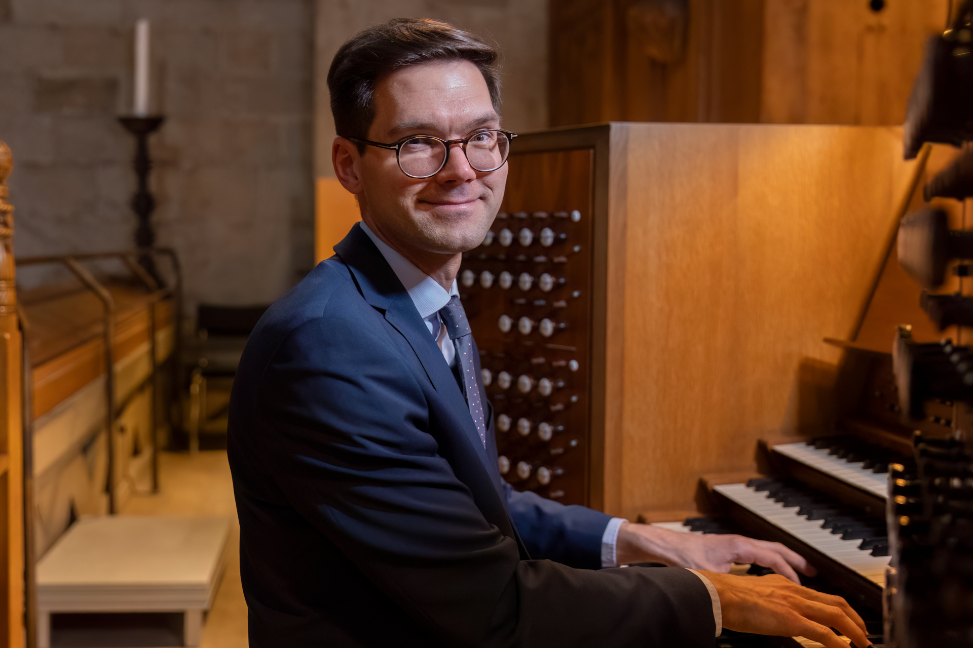 Robert Bennesh i blå kostym och vit skjorta sitter på orgelpallen vid stora orgeln i Lunds domkyrka.