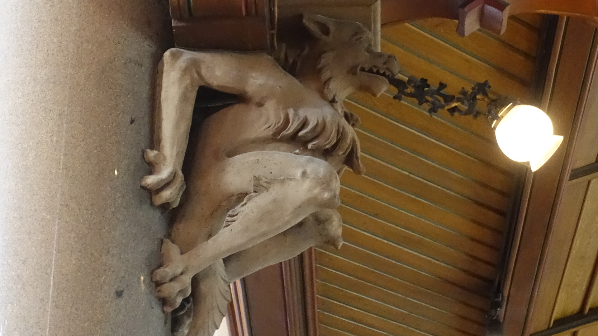 Bild på en gargoyle under läktaren som lamphållare.