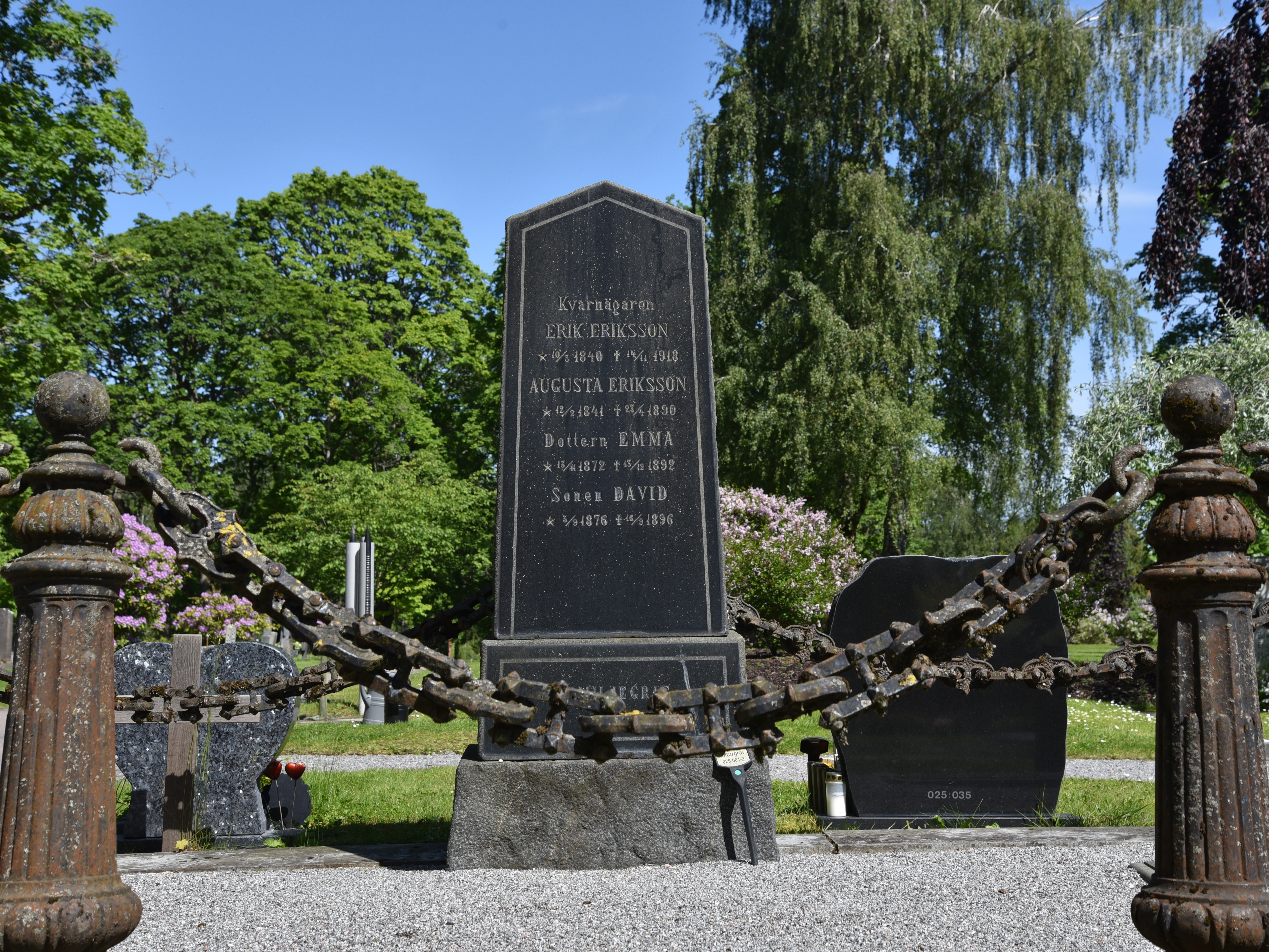 Avskalad gravsten i granit med polerad framsida som utmärks av en rak och ljus konturlinje.  