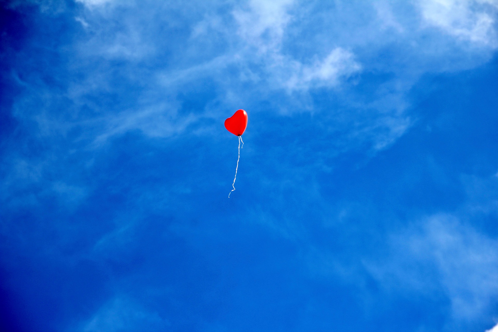 Röd ballong på blå himmel