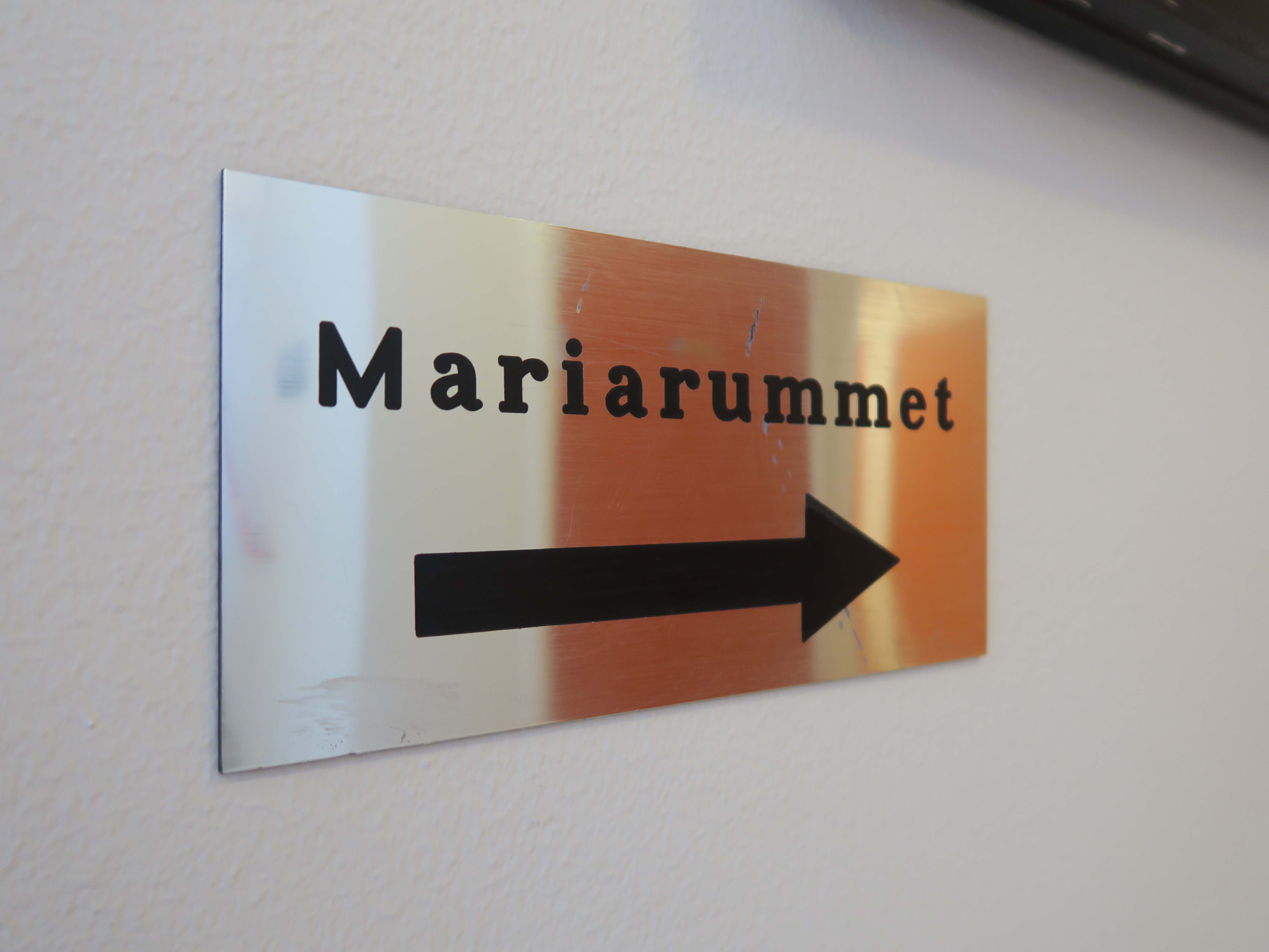 En blank skylt med texten "Mariarummet" och en pil.