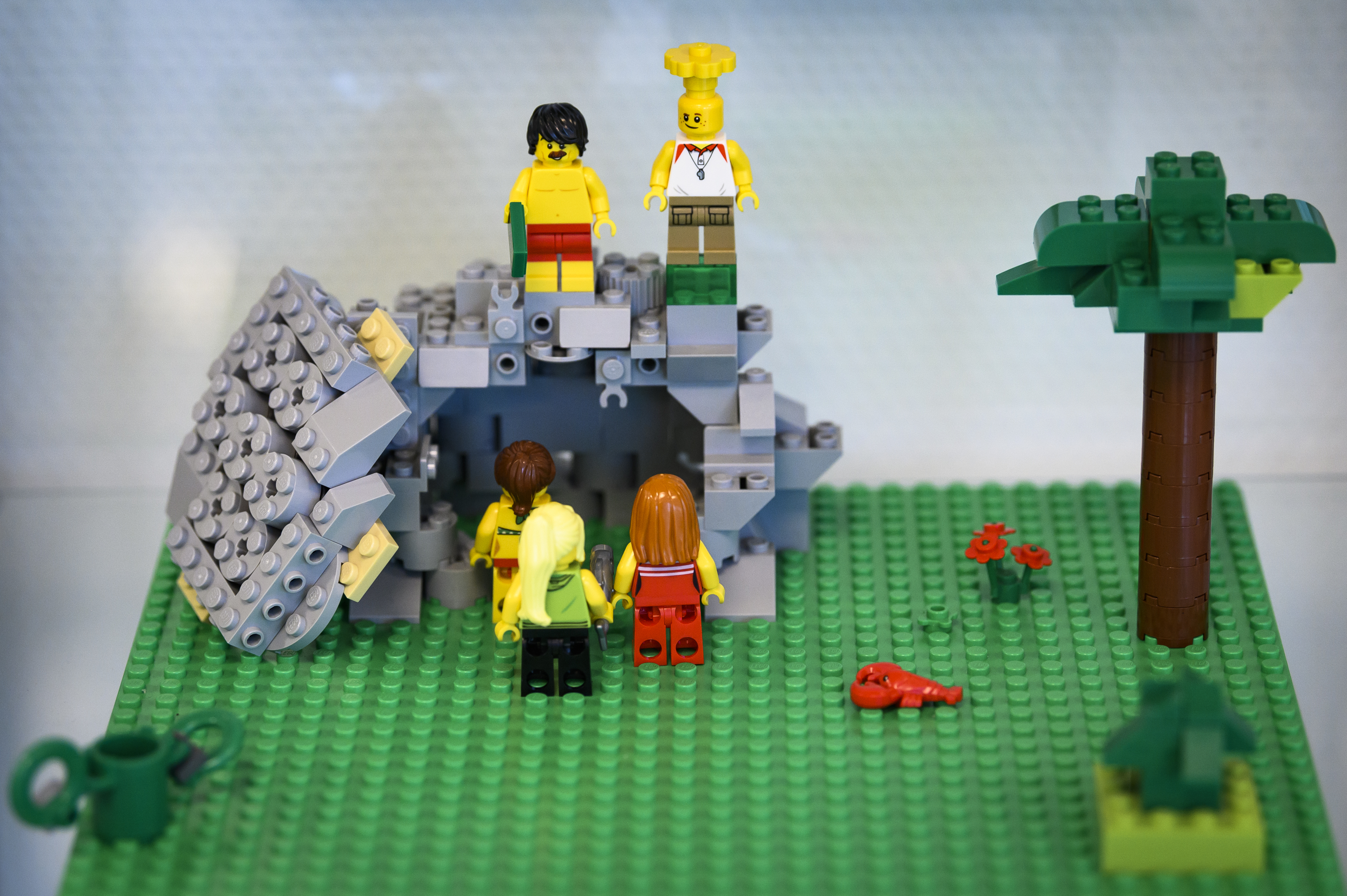 Någon har byggt med Lego: några personer står utanför en tom grotta där dörren vräkts åt sidan.