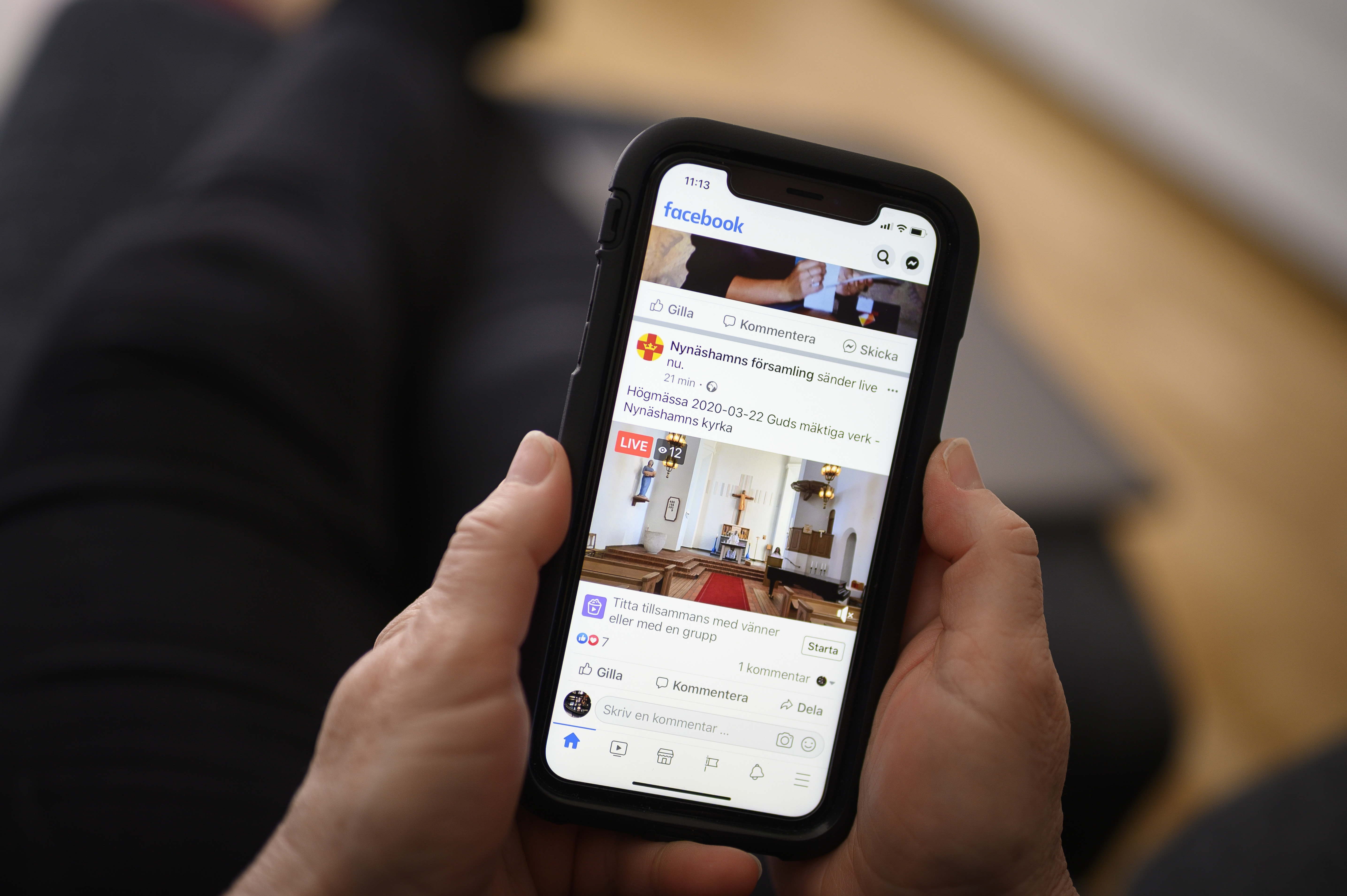 Någon är inne på Svenska kyrkans Facebook-sida på mobiltelefonen.